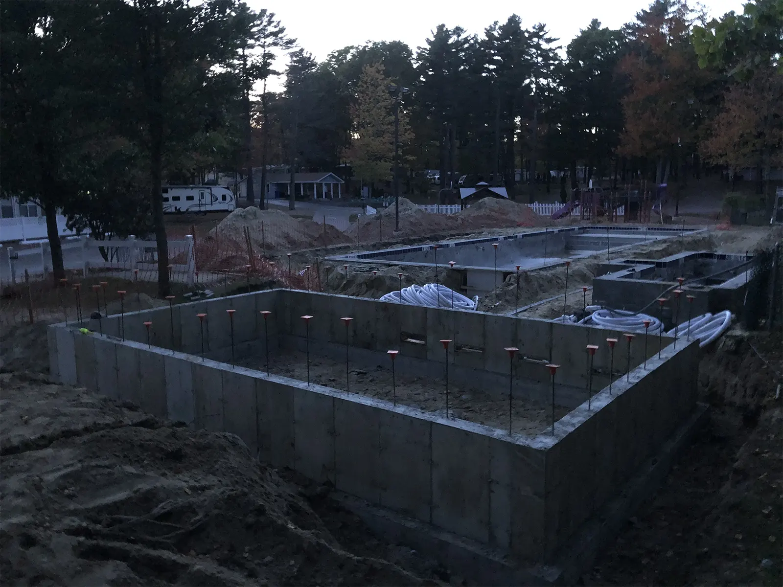 Newly poured concrete foundation walls with anchor bolts for a pool pump house built by J-PAC Construction