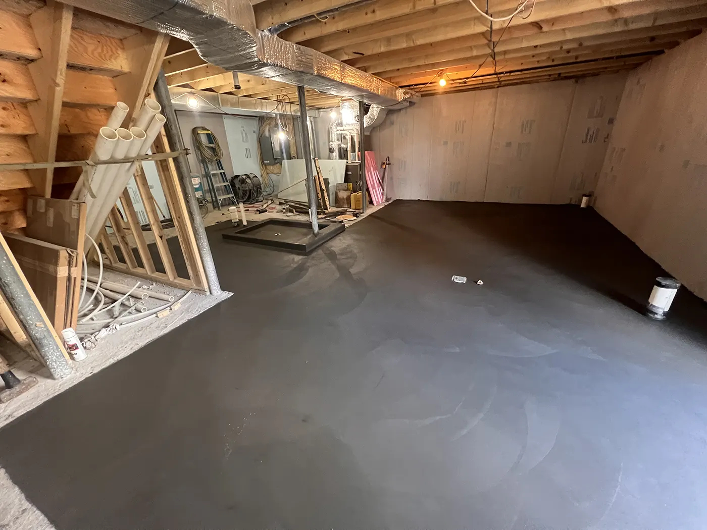 J-PAC Construction hand-troweled basement concrete floor slab with charcoal integral color