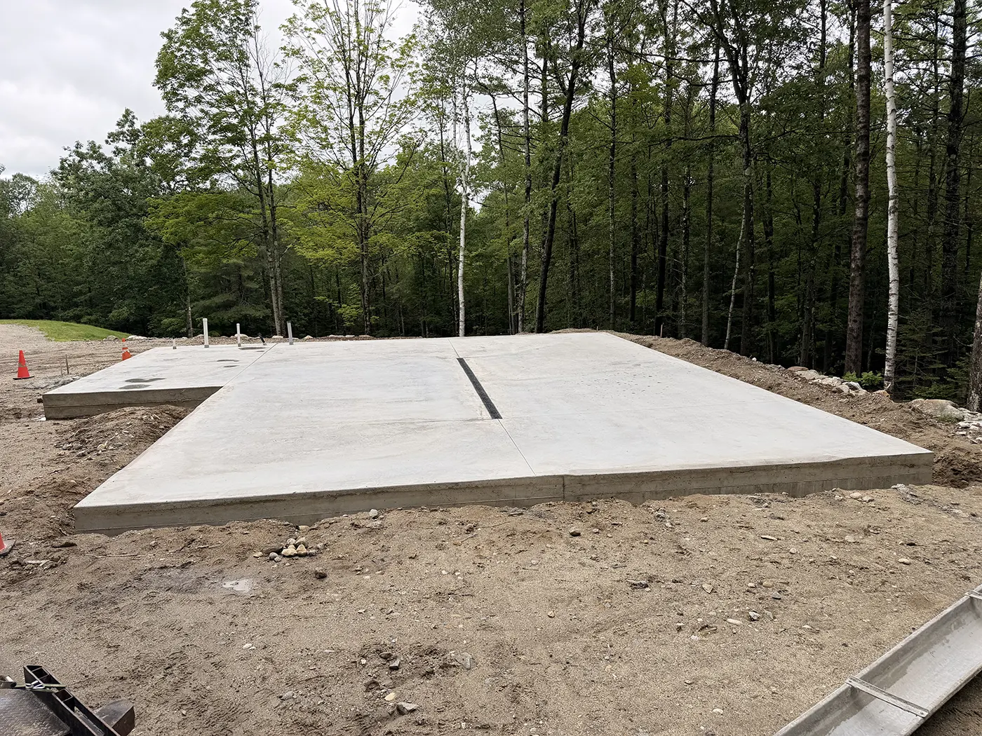J-PAC Construction freshly poured monolithic concrete slab on a cleared wooded lot